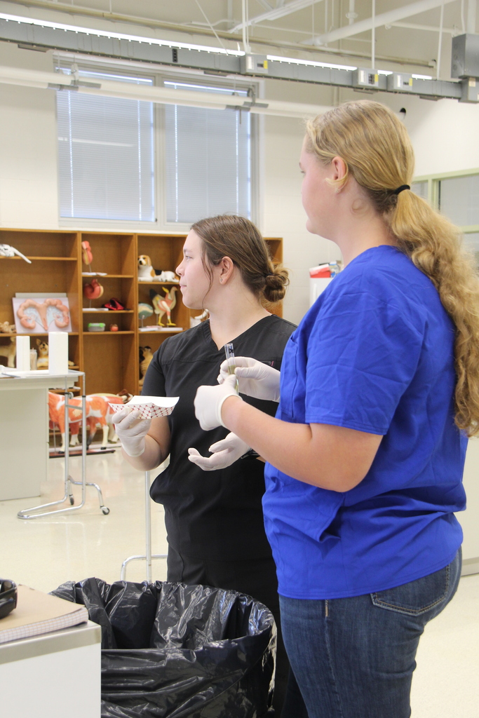 2 students holding urine samples for a urinalysis. 