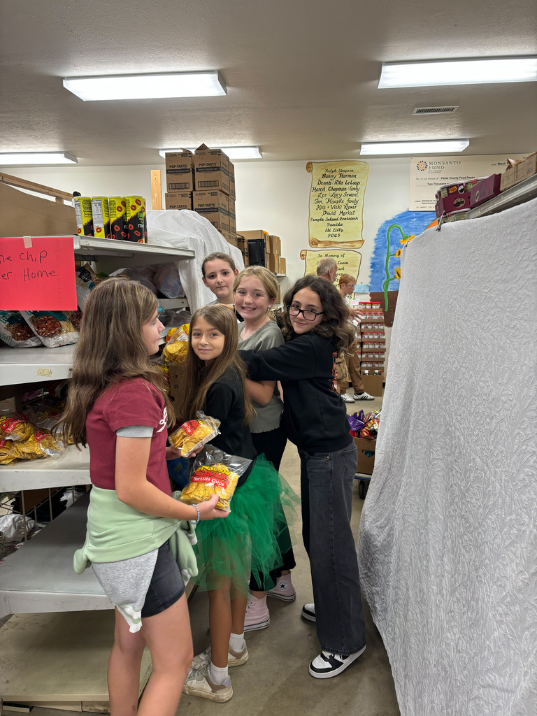 Five students helping stock shelves.