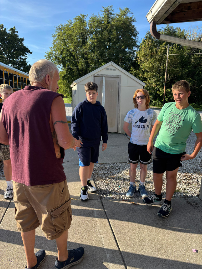 One adult talking to the students about the happenings of the time spent there. 