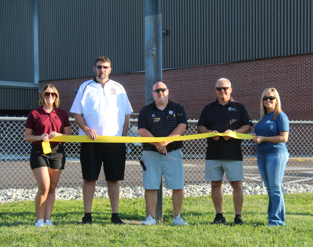 3 individuals from Riddell National Bank and the principal and the athletic director at the ribbon cutting ceremony.