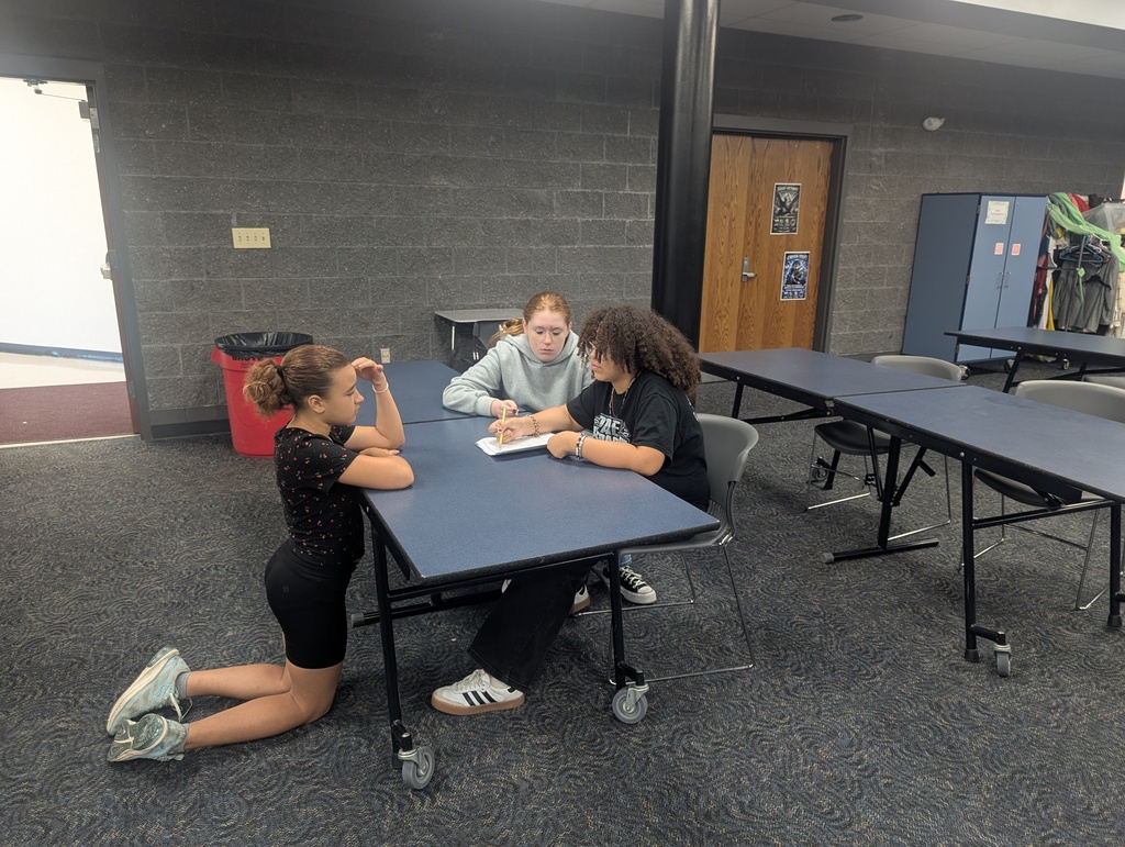 3 students writing their conclusion of their findings during their hypothesis.