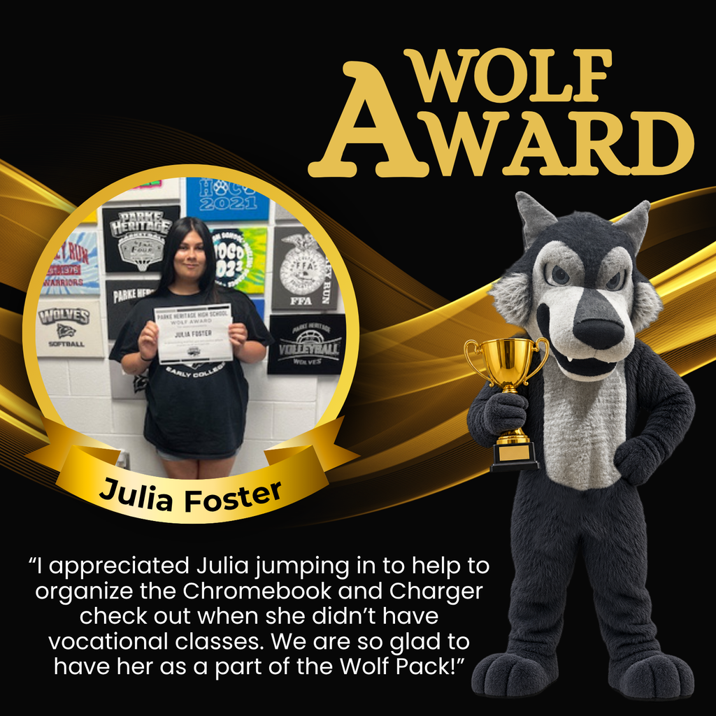 Photo of Julia holding her Wolf Award certificate in front of a wall decorated with Parke Heritage and school activity signs.