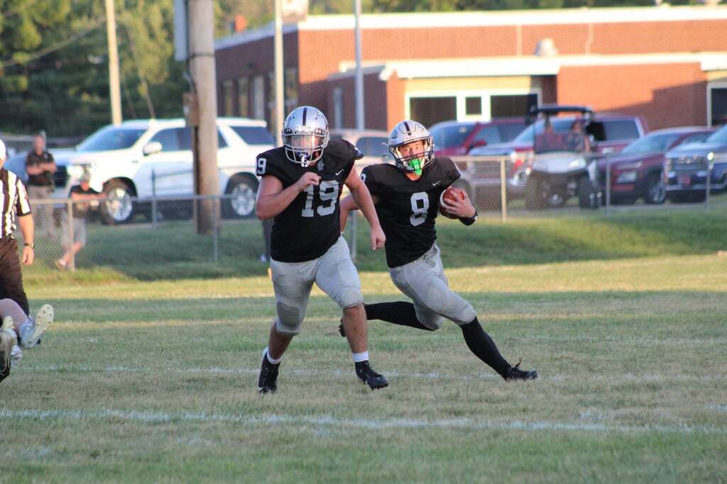 Two Parke Heritage players run with the football as they move past defenders.