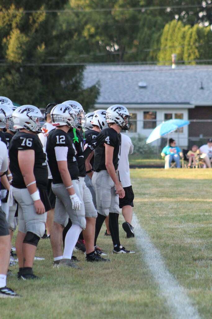 Parke Heritage football players stand together on the sideline during the game.
