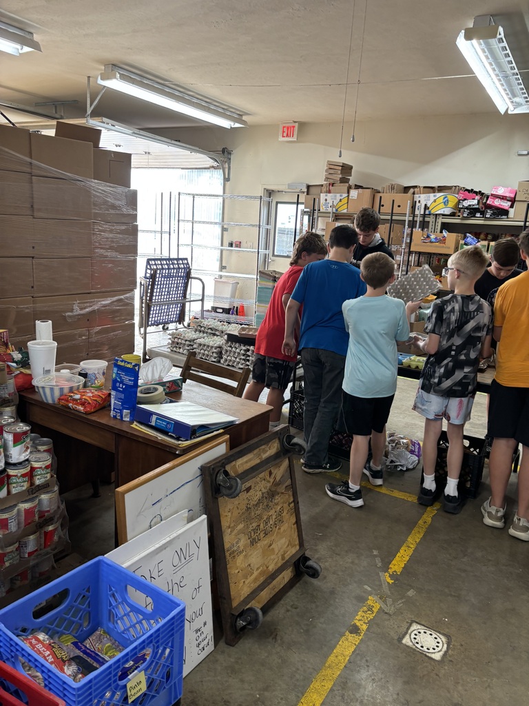 A group of students volunteers inside the food pantry, helping organize food and supplies while working together as a team.