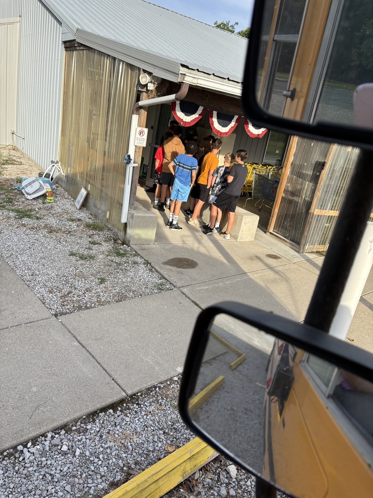 A group of middle school students arrives at a community food pantry from a school bus to volunteer and help serve their community.