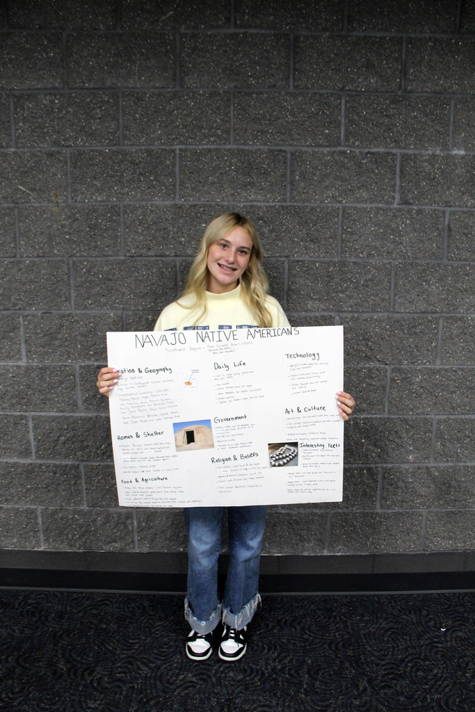 8th grade social study students have been learning about Pre-Columbian Native American groups. Student is holding her poster about the Navajo Tribe.