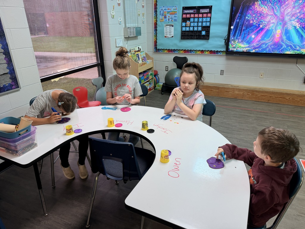 4 students playing with playdoh during fine motor skills learning. 