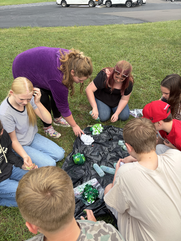 8 students sitting in a circle tie-dying their shirts at the Bindi BBQ.