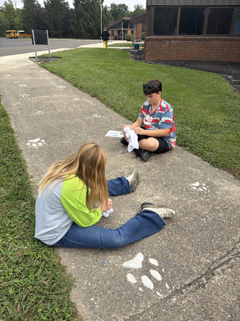 2 students rolling their shirts to tie-dye them at the Bindi BBQ.