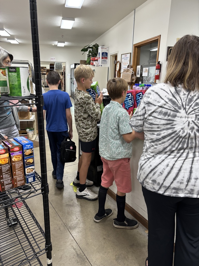 One student walking through, 2 students unpacking soda, and one adult supervising. 