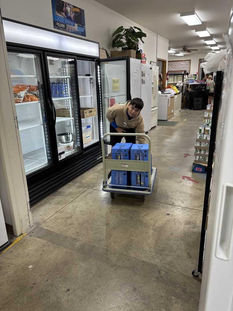 One student putting cold items away in the refrigerator. 