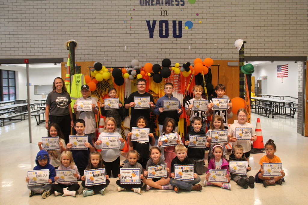 Mrs. VanDeusen's Character Builder Award winners for september 25, pose for a photo in front of the hand made construction worker background.