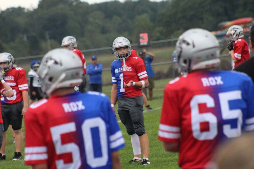 PHMS Football players discussing a play, getting ready to get in stance for the game. 
