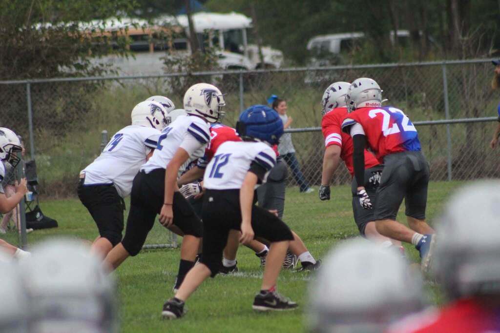 PHMS football players and opposing team running at each other during a play. 