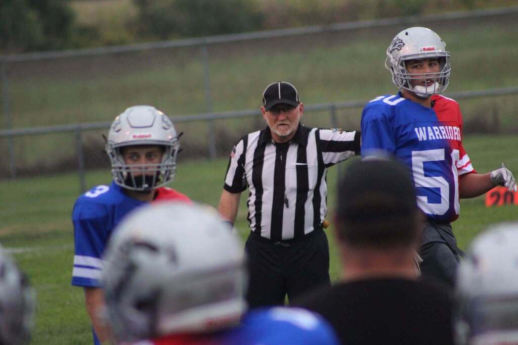 The referee and 2 PHMS football Players during the game. 