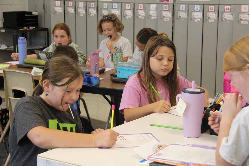 Several girls working on their worksheets. 