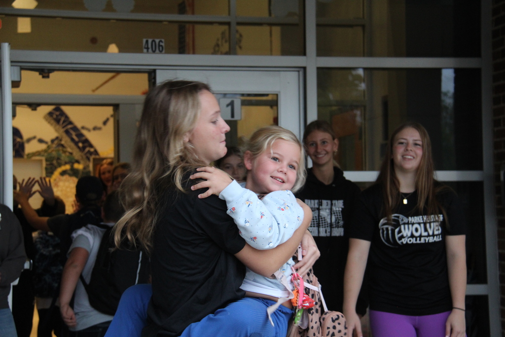 RES student hugging a PHHS Volleyball player before school starts on High Five Friday!