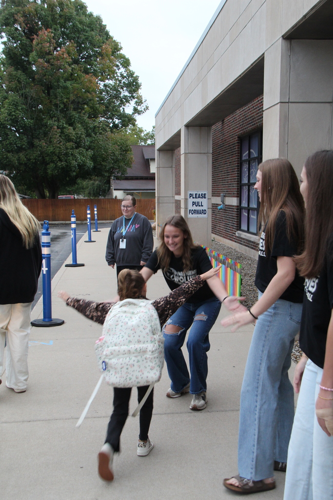 RES student running to hug one of the volleyball players before school on high five friday!