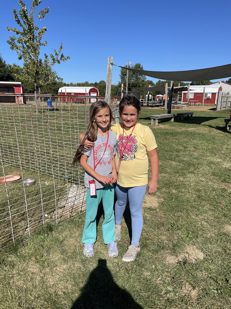 2 students pose for a photo while standing at hobson farms. 