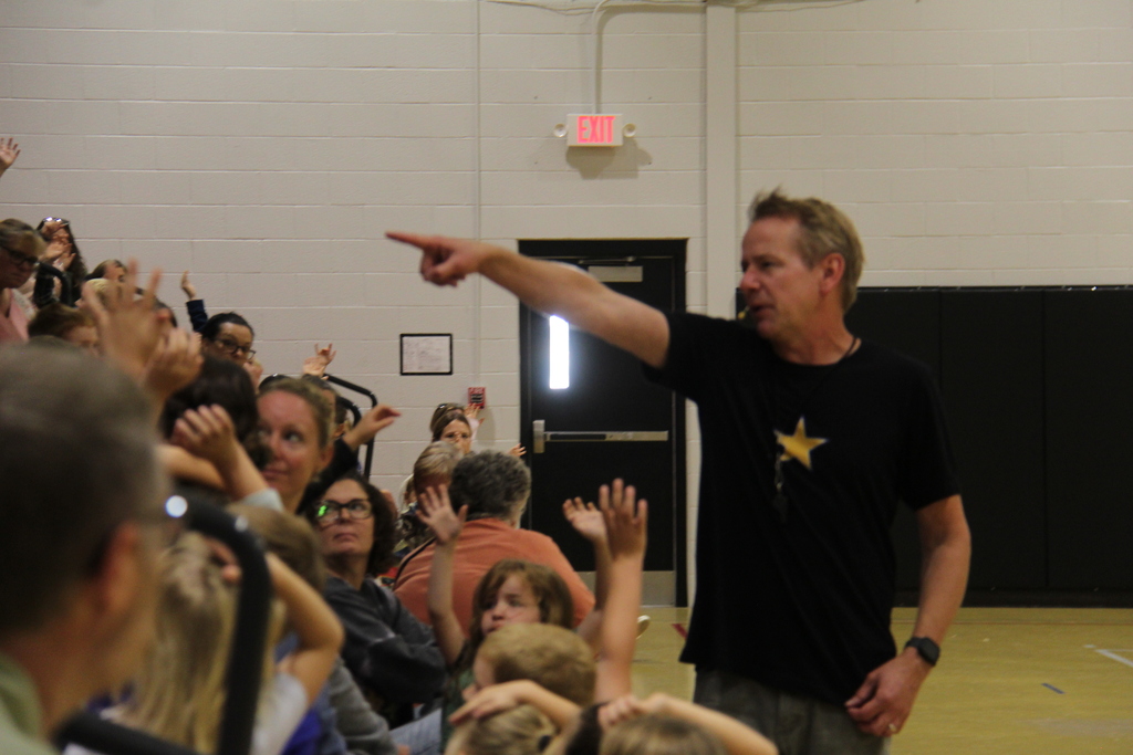The speaker choosing a volunteer. 