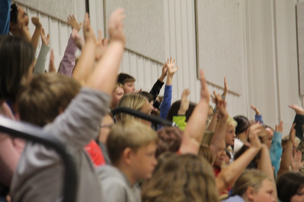 Students raising their hands to volunteer to help with the convocation.