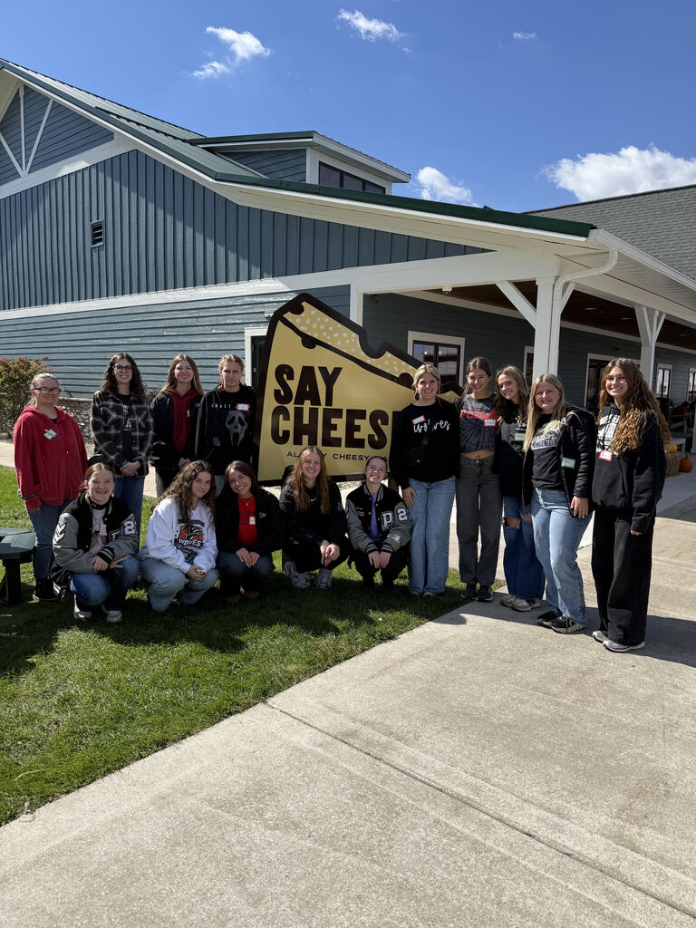 PHHS FCCLA students posing for a photo with a Say Cheese sign. 