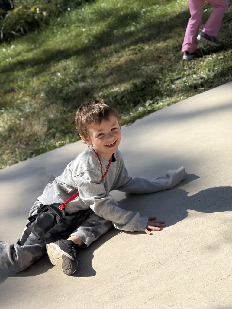 One student poses on the ground for a photo. 
