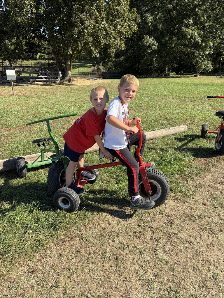 2 students rid on a tricycle together. 