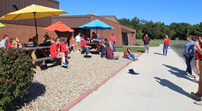 students sitting at the picnic tables during the House meeting
