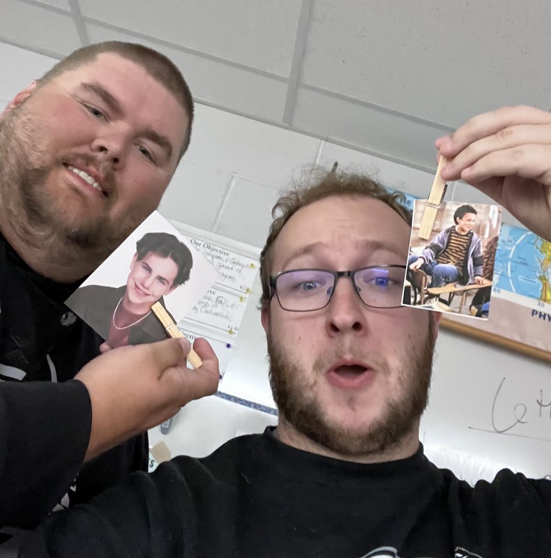 two staff members holding photos