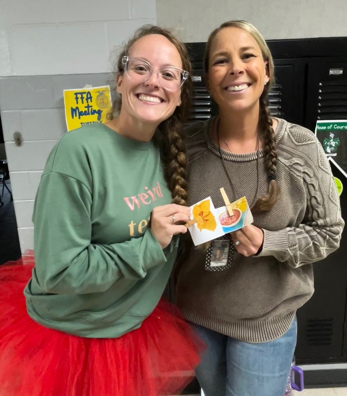 two teachers holding photos