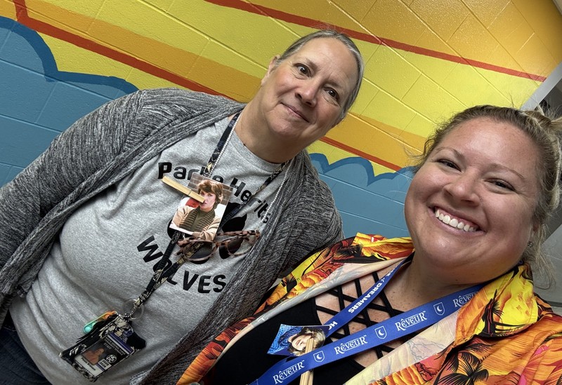 two teachers holding photos