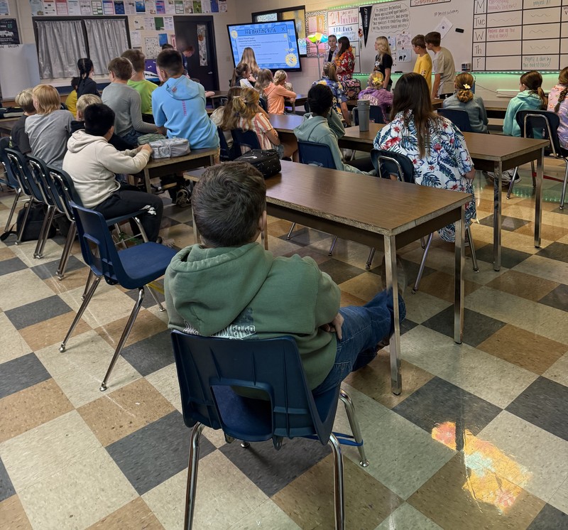 students sitting at tables listening to the officers speak