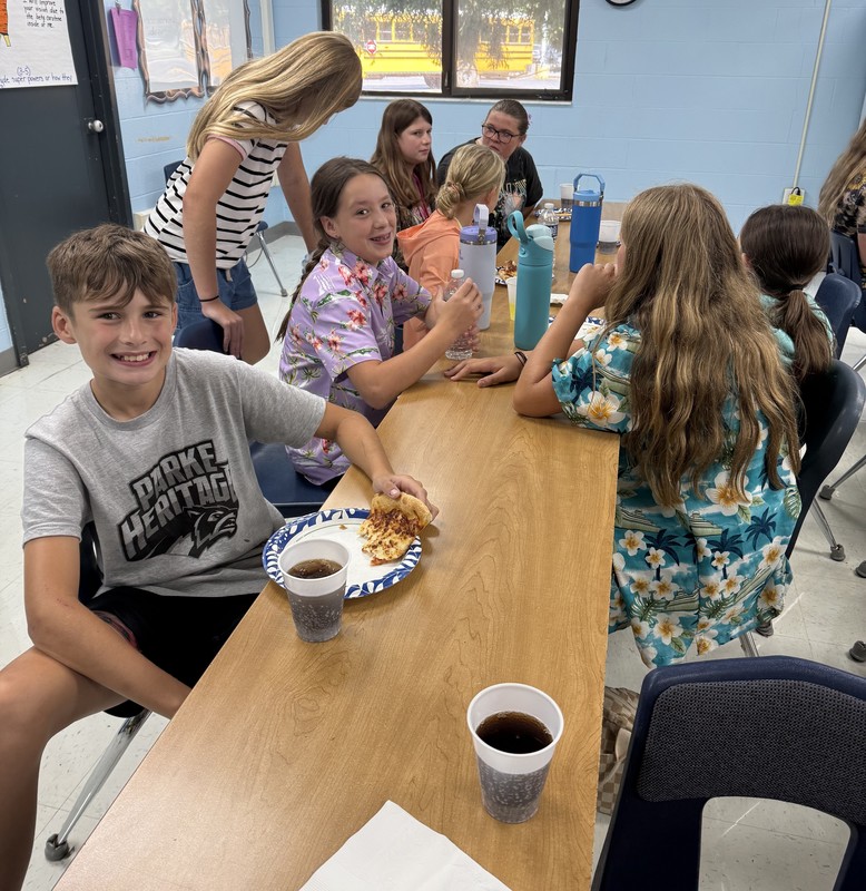 students sitting at a table eating lunch