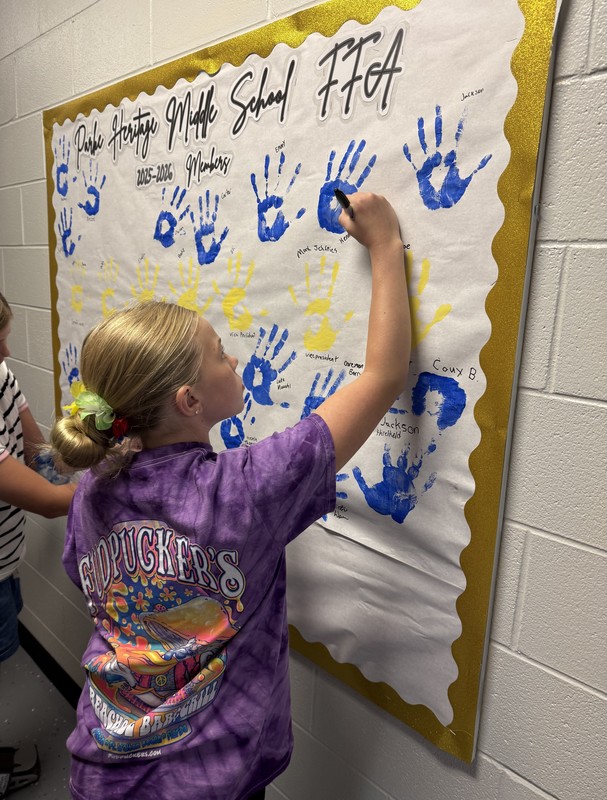 student signing her name on the bulletin board