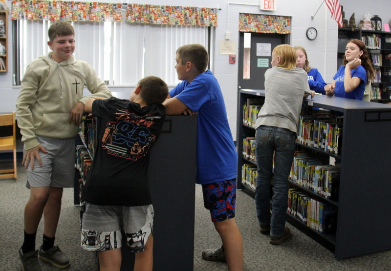 students standing in groups in the library