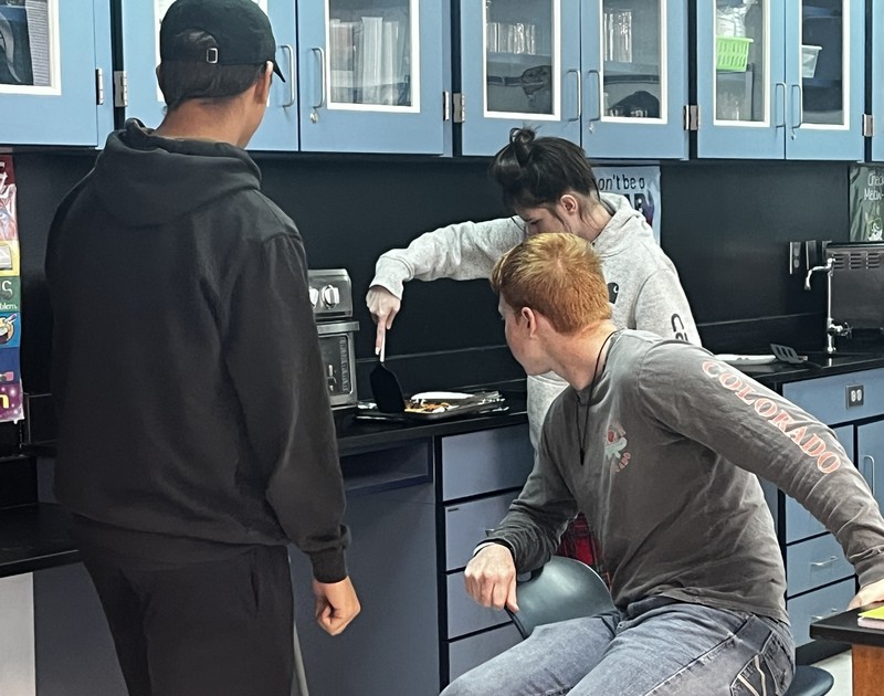 students checking their pepperoni pizza to make sure it's done