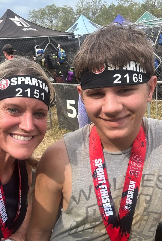 women and a teenage boy standing together wearing medals