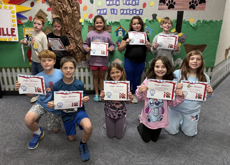 students sitting, kneeling and standing and holding certificates