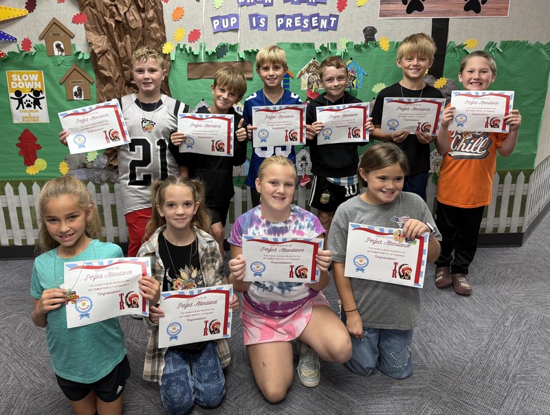 students sitting, kneeling and standing and holding certificates
