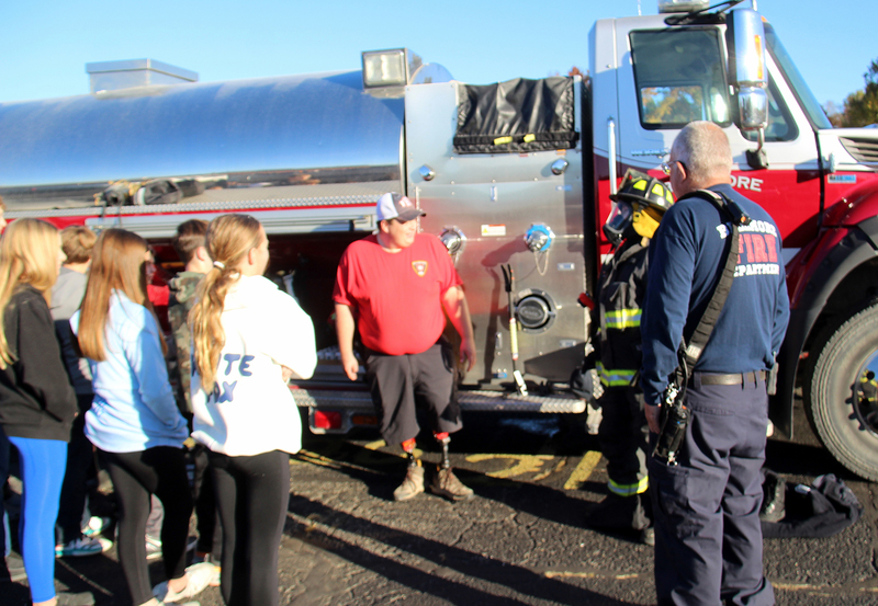 fire fighters showing fire gear to students