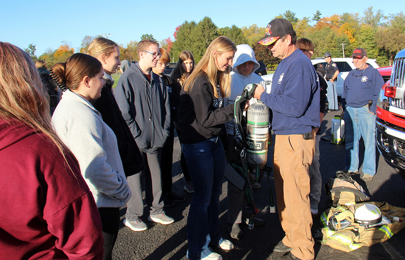 firefighter showing gear to students