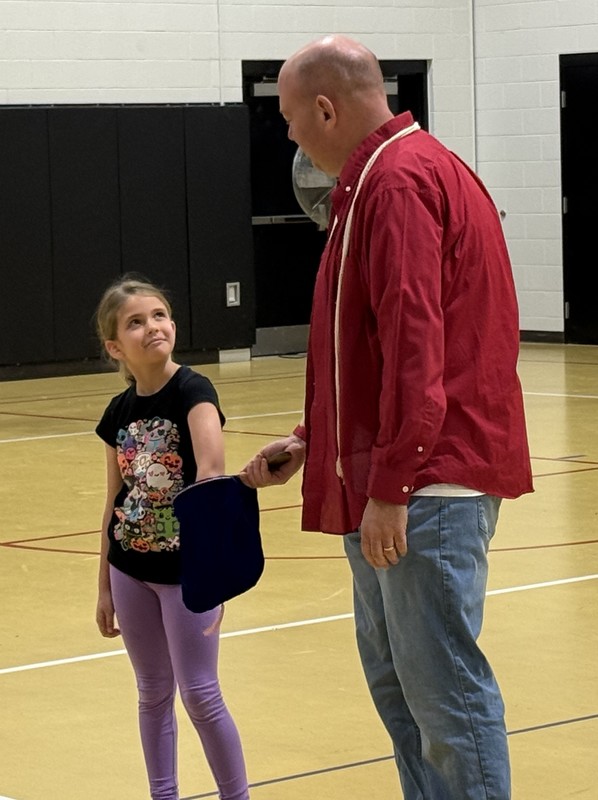 a student helping a magician with his act