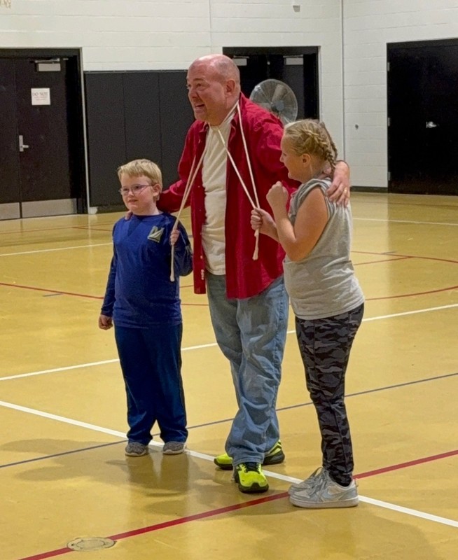two students helping a magiian with his act
