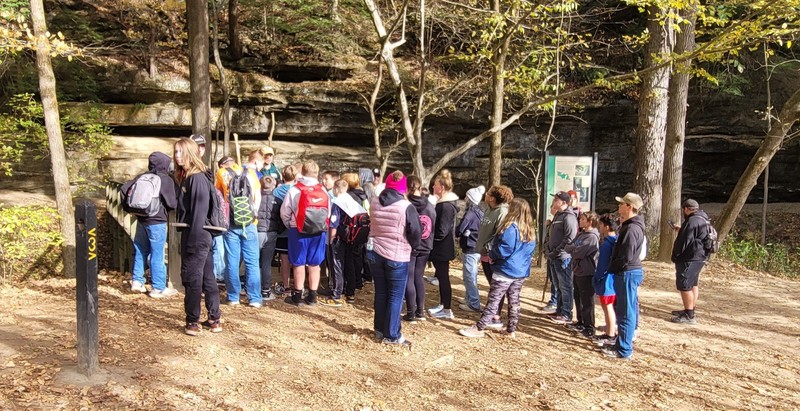 students standing in a group listening to a park ranger