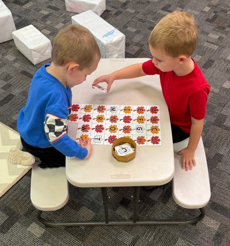 preschool students sitting at an activity table