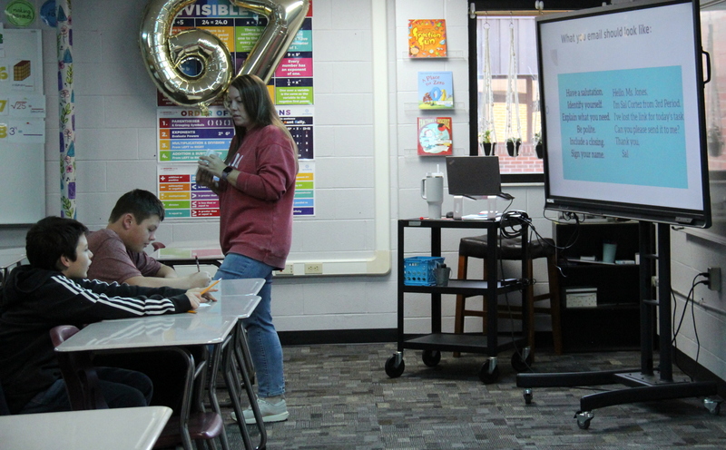 teacher and students sitting at desks