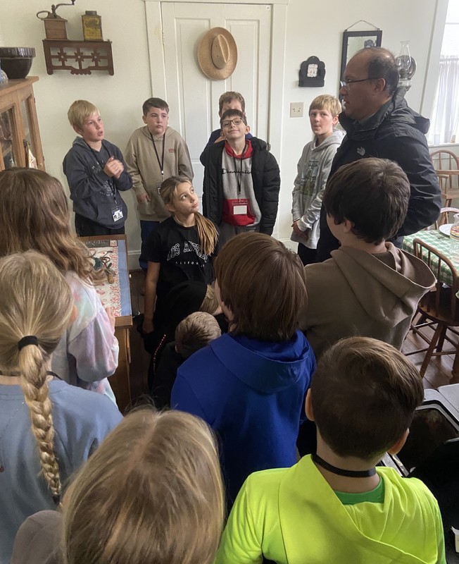 students listening to the tour guide in the Ernie Pyle house