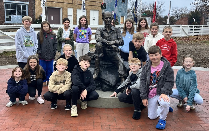 students sitting and standing by the Ernie Pyle statue